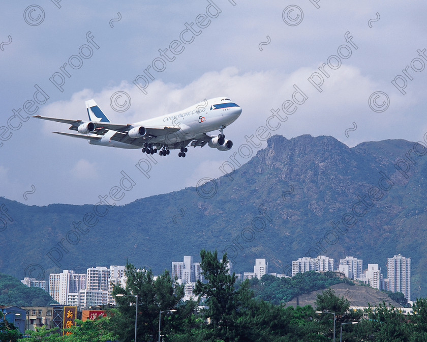 Approach to Kai Tak 
 Cathay Pacific B747-300 approaching the old airport at Kai Tak, Hong Kong. Lion Rock in the background 
 Keywords: Cathay Pacific, Hong Kong, Kai Tak airport, Lion Rock, B747, Boeing, wide body, heavy, airlines, mountain, approach, landing, terrain, civil aviation, aircraft, China, travel, Far East, tourism,